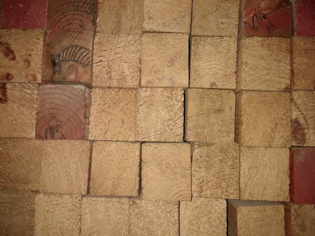 Un salon moderne et chaleureux avec des panneaux acoustiques en bois installés sur le mur derrière un canapé, démontrant une intégration esthétique et fonctionnelle.